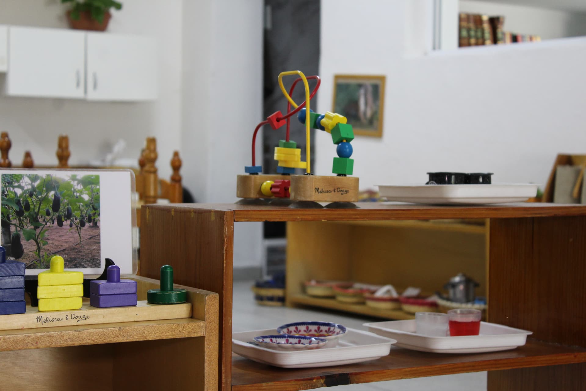 Estantes de madera con material Montessori en el ambiente preparado de Creeser