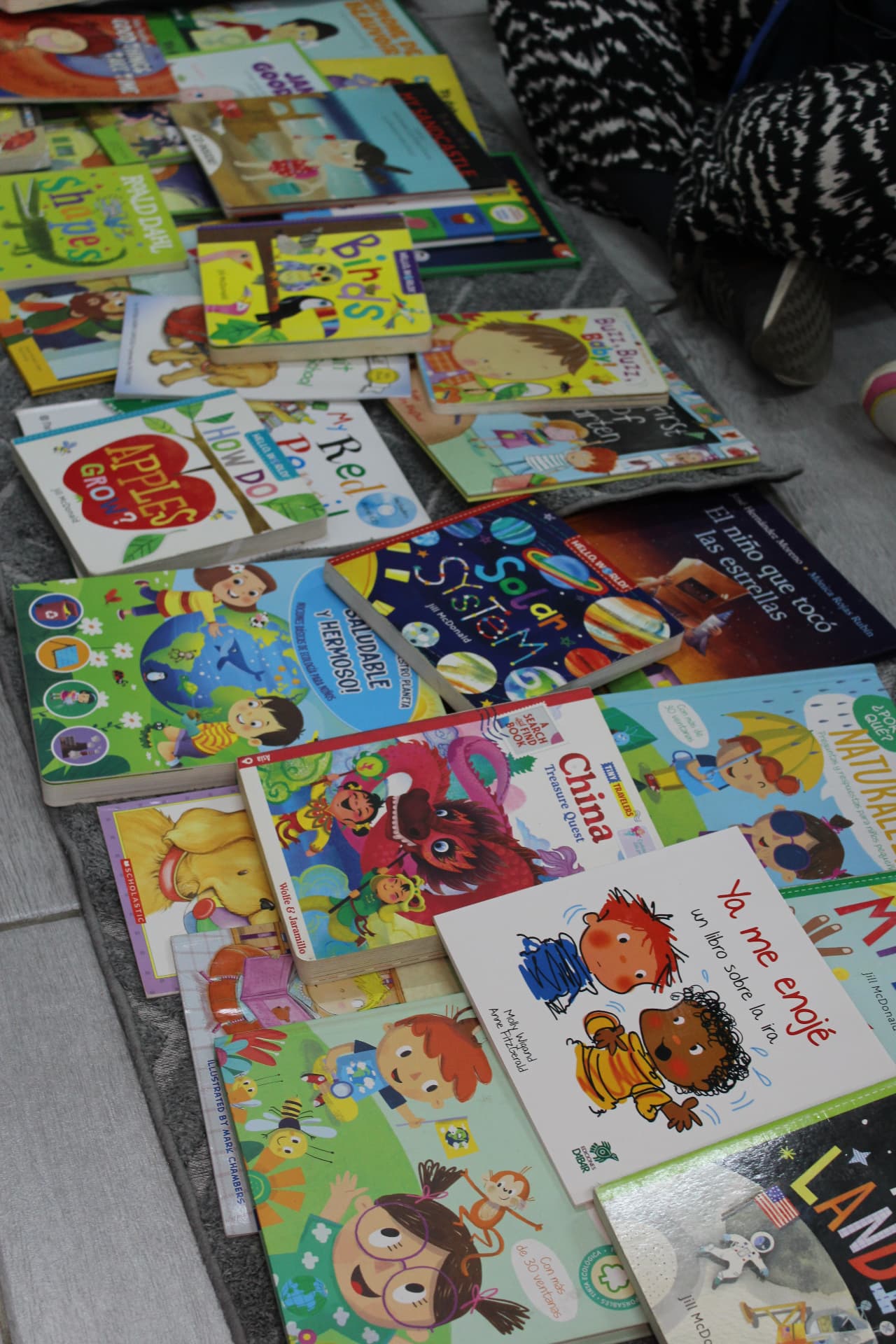 Libros infantiles apilados en español e inglés en Creeser Montessori